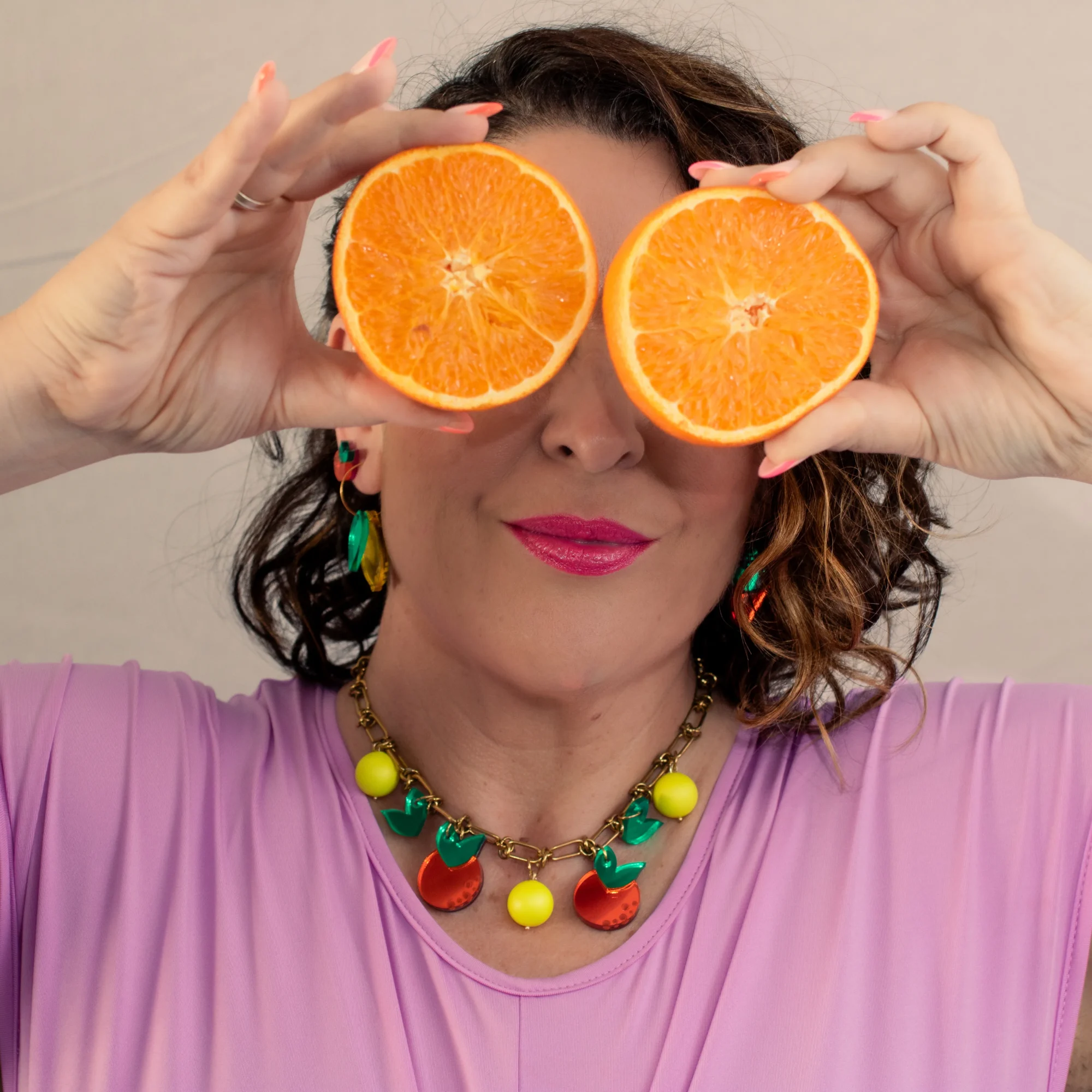 modelo con collar de naranjas en metacrilato y bolas fluor amarillas
