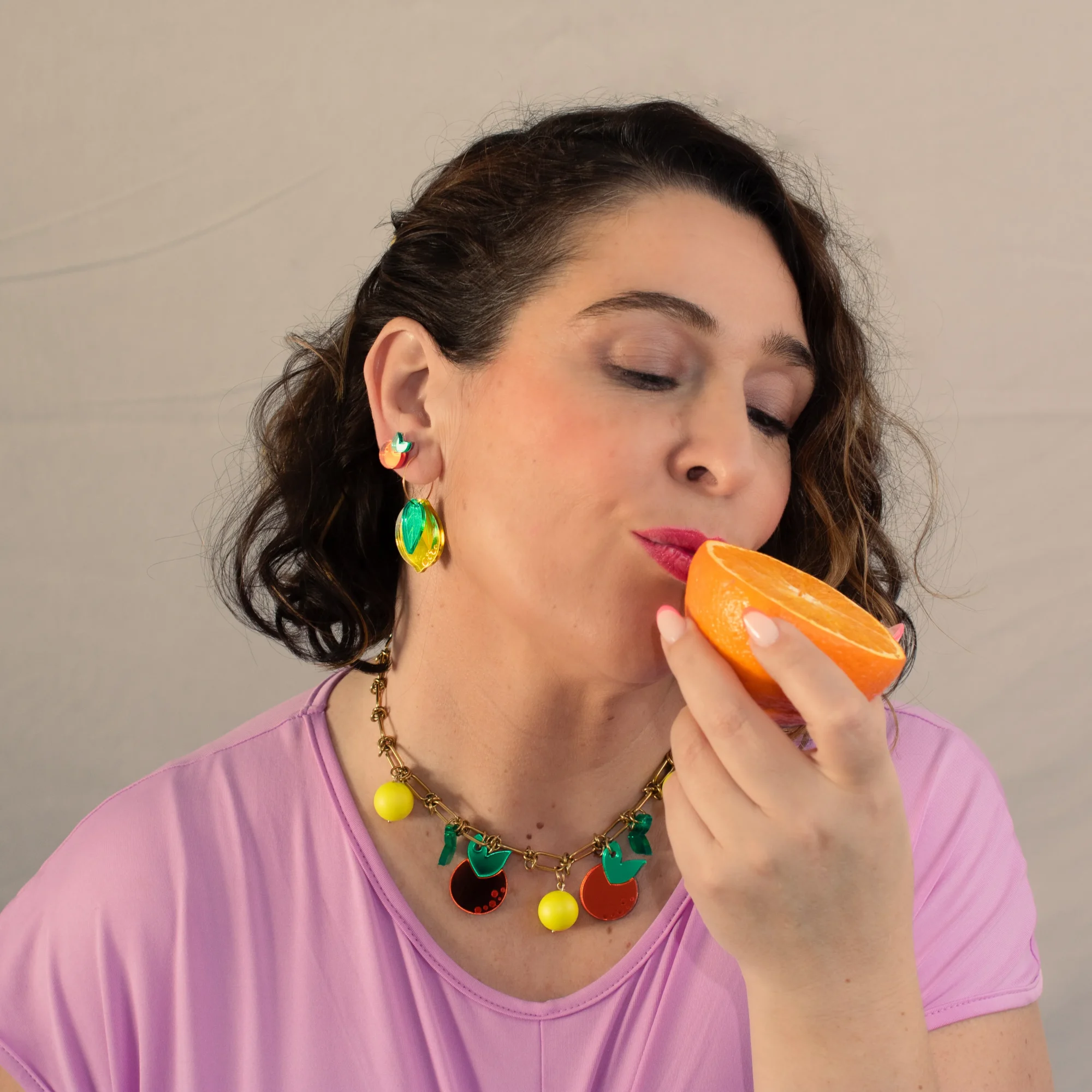 modelo con collar de naranjas en metacrilato y bolas fluor amarillas